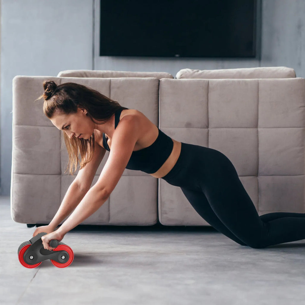 Woman using the ab roller for a kneeling rollout at home